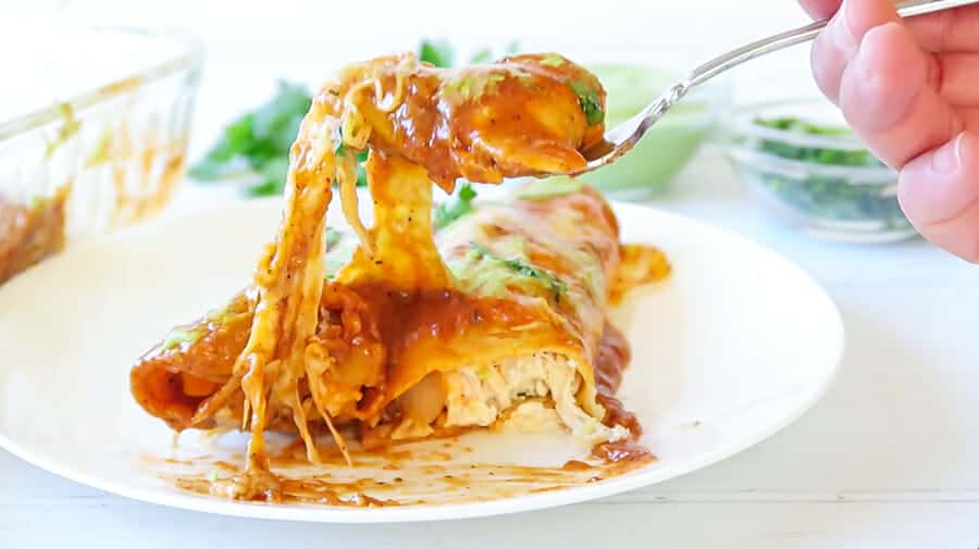  bite shot of the easy baked red chicken enchiladas (with Creamy avocado sauce drizzle0