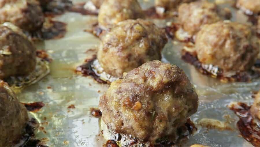 closeup of the best baked meatballs fresh out of the oven on a large sheet pan