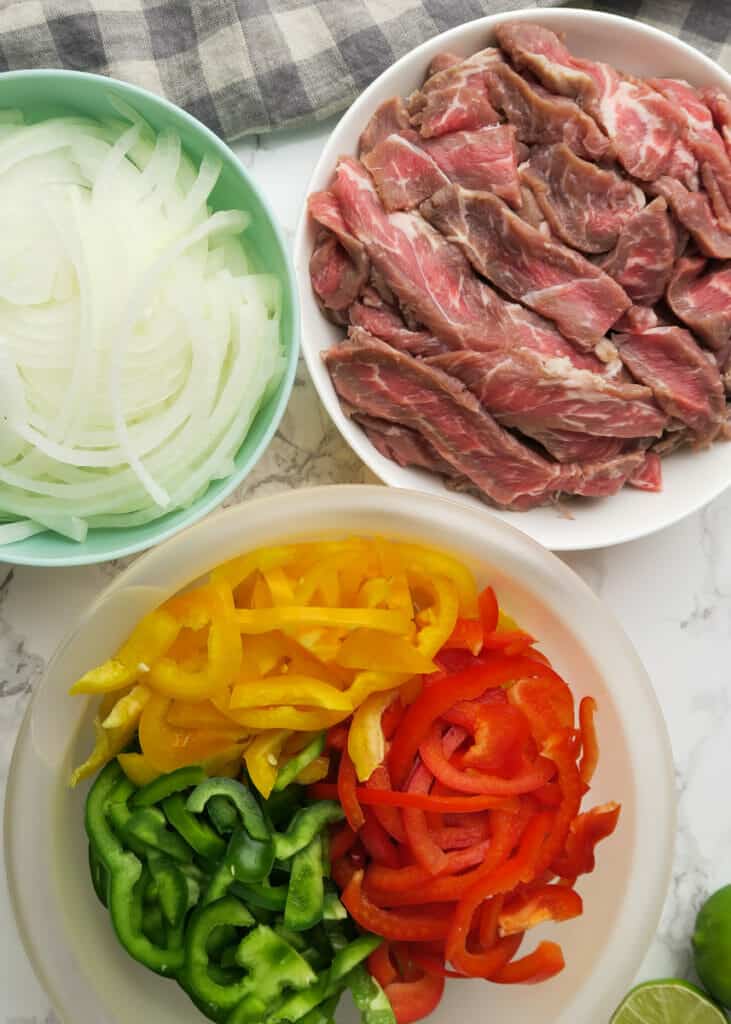 sliced petite sirloin steak and sliced bell peppers and onions