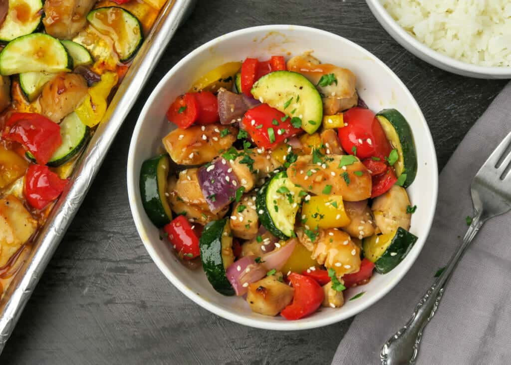 Sheet Pan Chicken & Veggies {Easy Kabob Alternative} served in a bowl with a side of rice