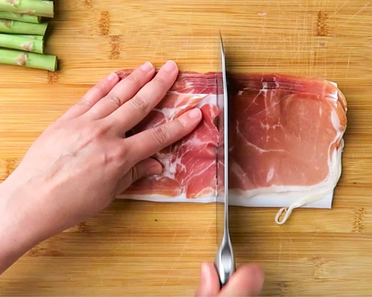 cutting the prosciutto in half